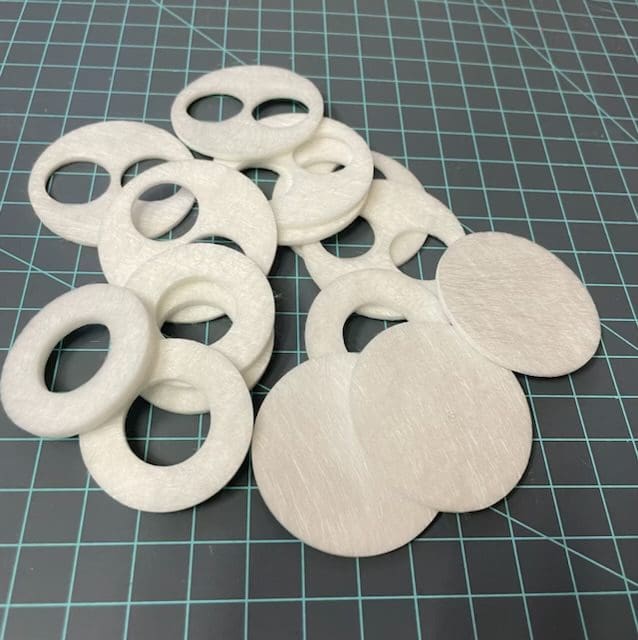 A pile of white paper mache discs on top of a table.