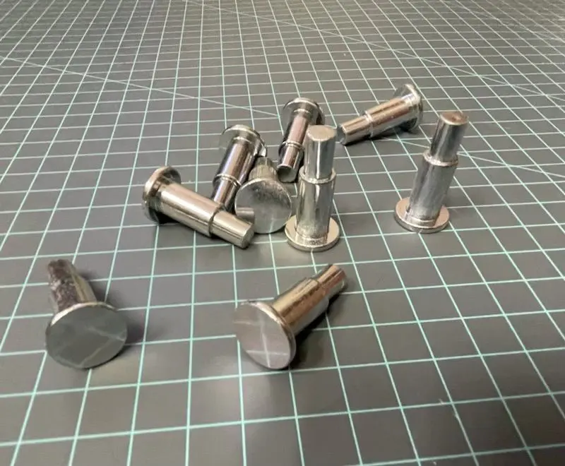 A group of metal nuts sitting on top of a floor.